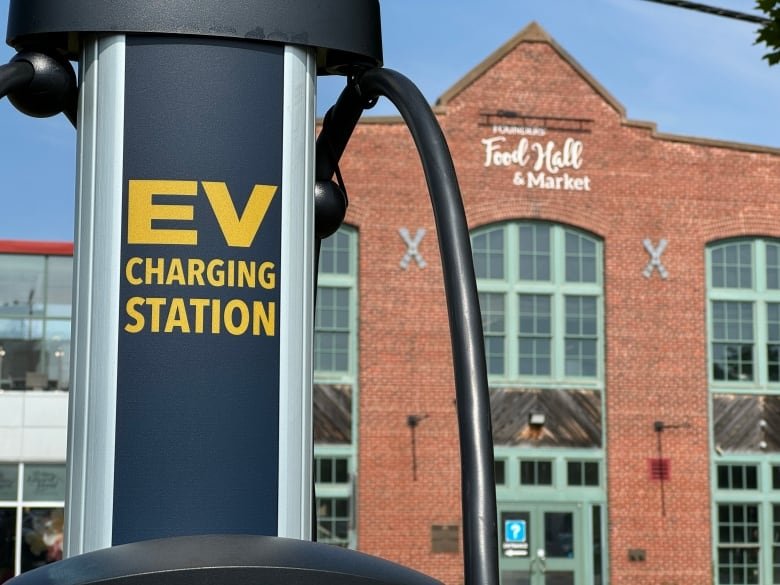 EV charger outside a brick building with sign that reads 'Food hall and market'