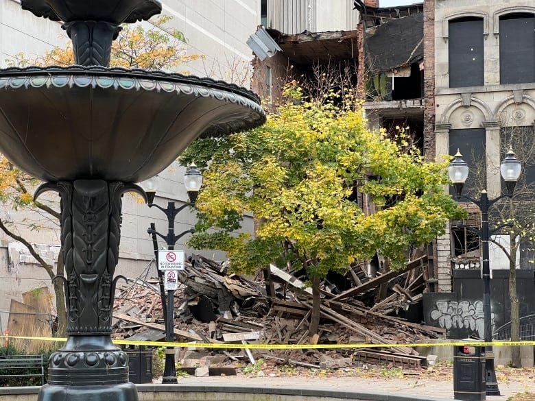 a pile of rubble lays on the ground in front of a building with no facade