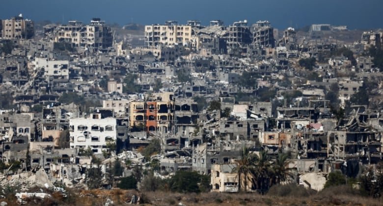 A number of destroyed buildings are shown from a distance. Almost all have blacked out, destroyed windows, and are just the grey skeletons of buildings.