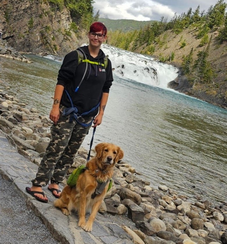 Woman and dog in front of a river