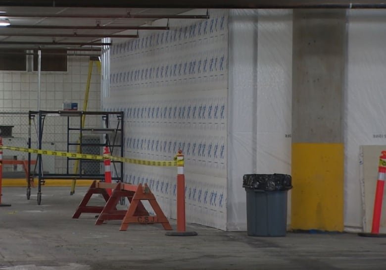 A parking garage with a pilon blocking off a wall.