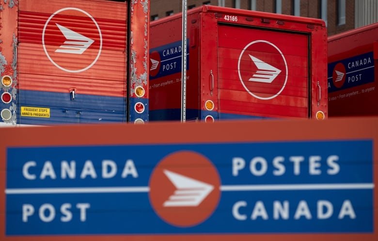 Canada Post signage and parked red vehicles at a Canada Post mail sorting facility