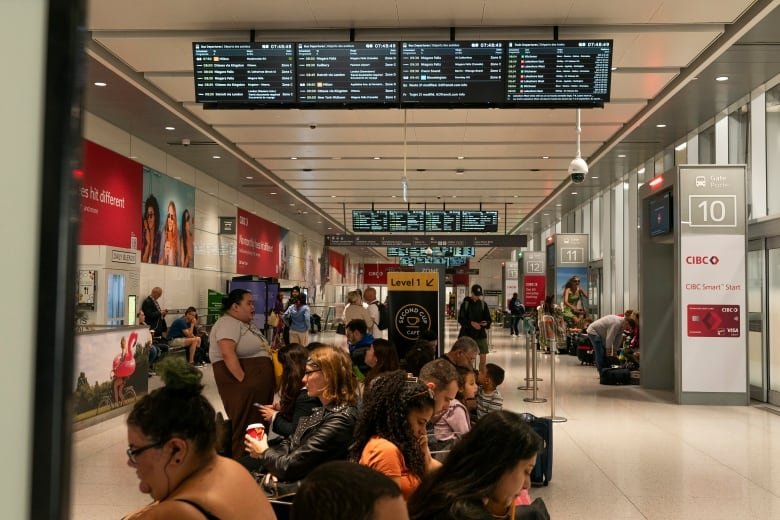 People wait inside at the Union Station bus terminal as a national rail shutdown causes delays, after employees were locked out by both major Canadian railways after a deadlock in contract negotiations, in Toronto, Thursday, Aug. 22, 2024.