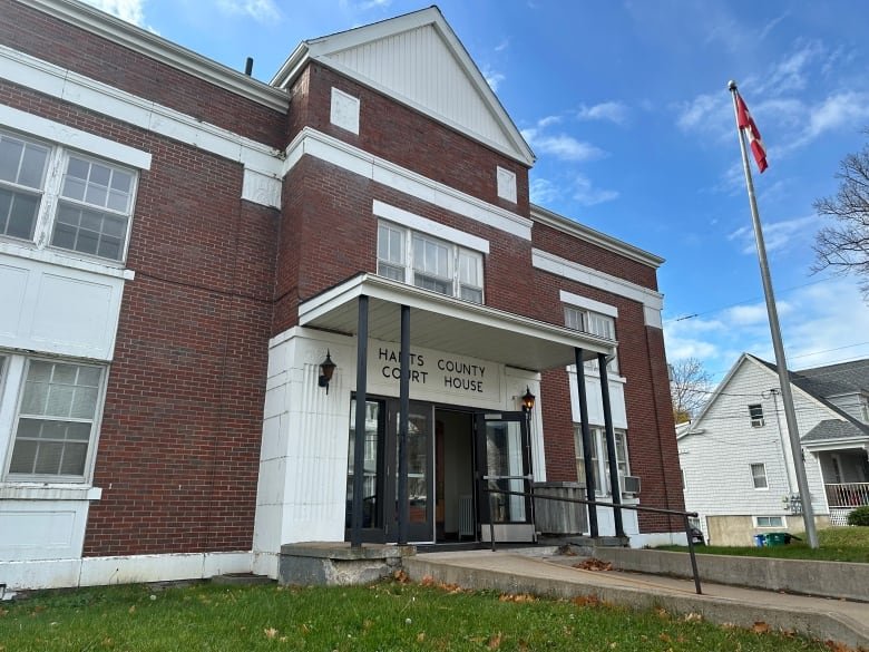 A brick building with a Canadian flag beside it is shown.