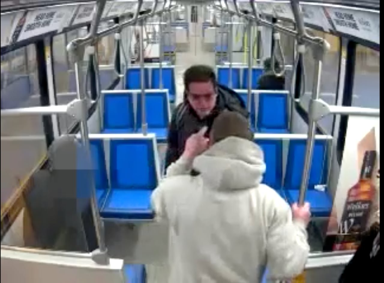 Two men on a transit vehicle.